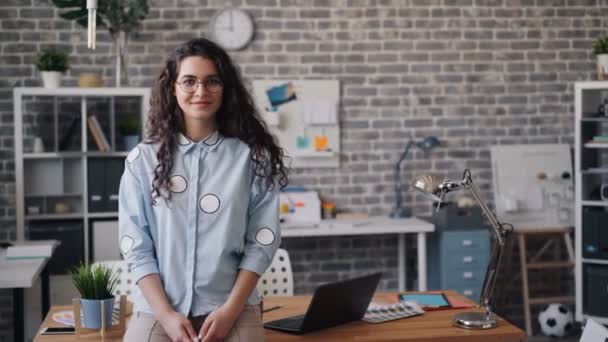 Ofiste tek başına duran ve gülümseyen güzel kız girişimci portresi — Stok video