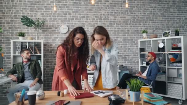 Creatieve ontwerpers organiseren dingen op het Bureau om platte lagen in kantoor te schieten — Stockvideo