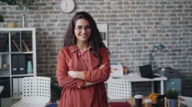 Güzel kadın mutlu ofis çalışanı portre kapalı ayakta ve gülümseyerek