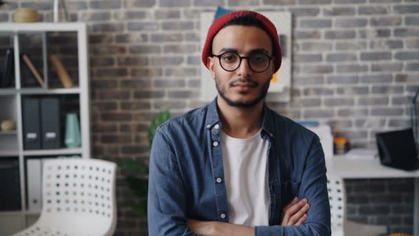 Retrato en cámara lenta del diseñador masculino mirando a la cámara y sonriendo en la oficina — Vídeos de Stock