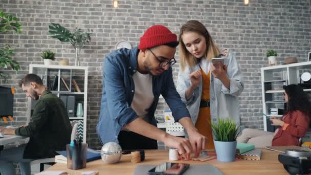 Collega's creatieve ontwerpers schieten platte lay in Office met slimme telefoon camera — Stockvideo