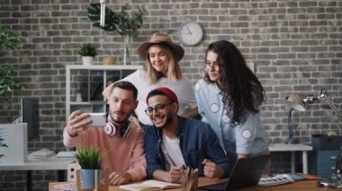 Akıllı telefon kamerakullanarak ofiste birlikte selfie çeken kız ve erkek grubu