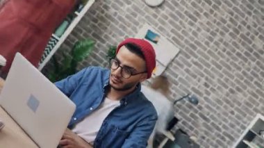 Loft ofis odasında bilgisayarla çalışan meşgul kişinin zaman atlamalı iplik