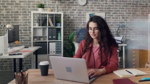 Тайм-ап занятой девушки-предпринимателя, работающей с ноутбуком в офисе в мансарде — стоковое видео