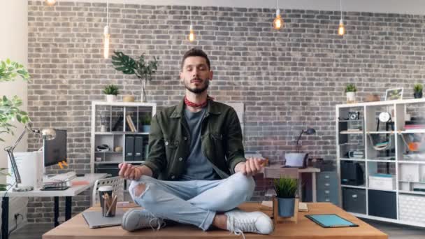 Time-lapse av stilig ung man koppla av i lotusställning på skrivbord i Office — Stockvideo