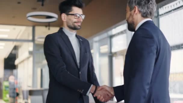 Partner commerciali in riunione formalwear in caffè stringendo la mano e parlando — Video Stock