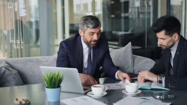 Boze zakenman scheuren papers gooien bij partner tijdens gesprekken in café — Stockvideo