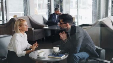 İş ortakları öğle tatilinde kafede işbirliği konusunu tartışıyor