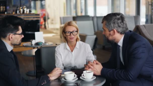 Veselá obchodní dáma, která vyjednával dohodu s partnerskými partnery, kteří se sešli v kavárně — Stock video