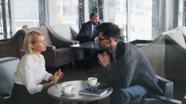 Socios de negocios discutiendo cooperación en café hablando durante el almuerzo — Vídeos de Stock