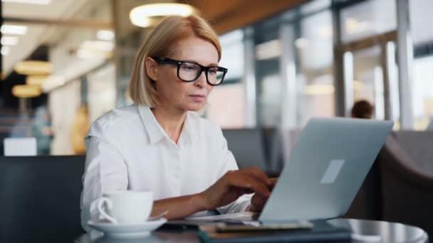 Empresário ocupado mulher sênior trabalhando com laptop digitação no café moderno — Vídeo de Stock