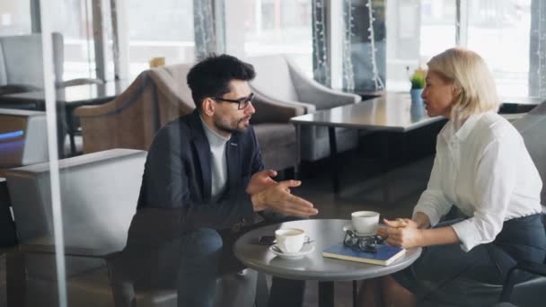 Зріла бізнес-леді обговорює бізнес з успішним партнером в кафе — стокове відео