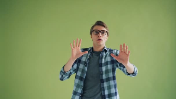 Portrait of frightened hipster looking at camera with fear stretching arms — Stock Video