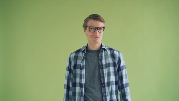 Retrato de hombre alegre mostrando pulgares hacia arriba y sonriendo sobre fondo verde — Vídeos de Stock