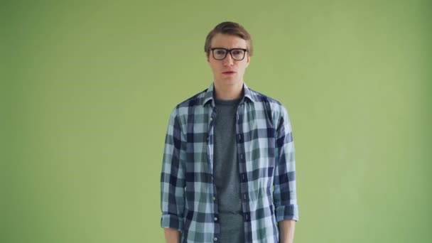 Portrait of disappointed man looking at camera on green background then leaving — Stock Video