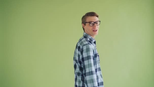 Portrait of joyful guy turning to camera and laughing on green background — Stock Video