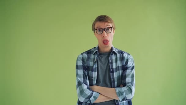 Porträt eines verspielten jungen Mannes Hipster macht lustige Gesichter Blick in die Kamera — Stockvideo