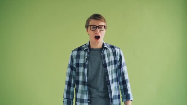 Portrait of sick guy sneezing then wiping nose and smiling looking at camera — Stock Video