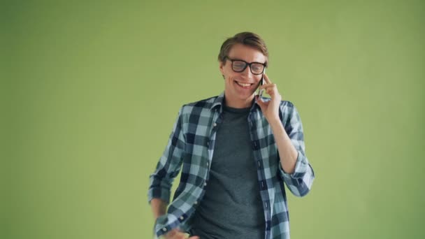 Retrato de estudante feliz do sexo masculino falando no telefone móvel gesticulando e sorrindo — Vídeo de Stock