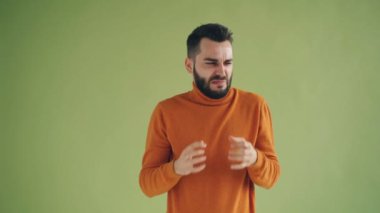 Yakışıklı genç adam koku kaşlarını burun alanınca sonra bırakarak burun buruşuk