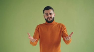 Belirsiz adam çok işaret gösteren sonra başparmak aşağı el hareketi ve kaşlarını çatma yüz