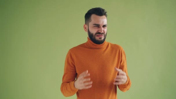 Felháborodott fickó mutatja hüvelykujját lefelé gesztus kezet és ráncos arc — Stock videók