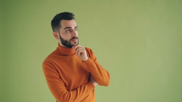 Portrét zamyšlého vousatého muže, který se díval na kameru na zeleném pozadí — Stock video