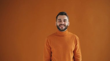 Ok el hareketi ve thumbs-up gösteren neşeli genç adam brunet Portresi