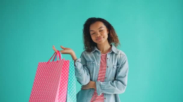 Porträt eines glücklichen afrikanisch-amerikanischen Mädchens mit Einkaufstüten zufriedene Kundin — Stockvideo