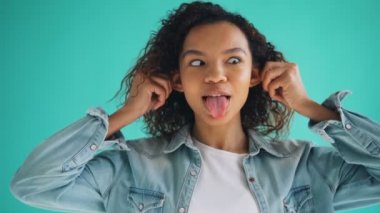 Sevimli Afrikalı-Amerikalı genç kız portre komik yüzler yapma ve gülme