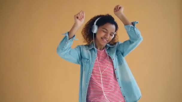 Retrato de una bella dama con auriculares disfrutando de la música y bailando divirtiéndose — Vídeo de stock