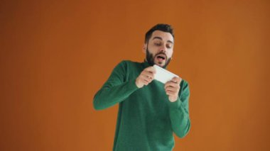 Akıllı telefon tutma gadget oyunu oynayan sakallı öğrenciportresi