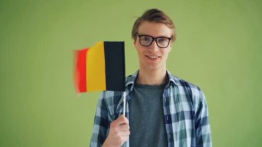 Alman bayrağı tutan ve gülümseyen neşeli kişinin yavaş çekim portresi