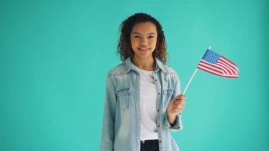 Abd bayrağı ile Afro-Amerikan bayan yavaş hareket kameraya bakarak gülümseyerek