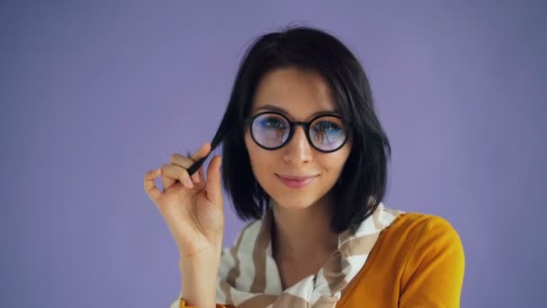 Retrato de linda chica estudiante enrollando el pelo alrededor del dedo sonriendo coqueteando — Vídeos de Stock