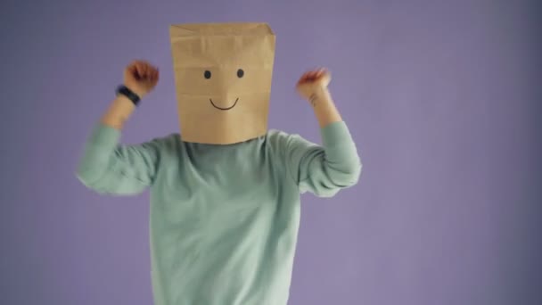 Portrait de femme joyeuse avec sac en papier sur la tête dansant en s'amusant relaxant — Video