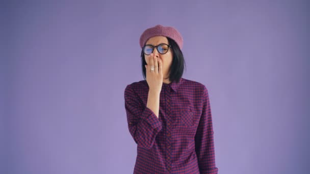 Retrato de morena cansada y somnolienta en gafas y sombrero bostezando mirando a la cámara — Vídeos de Stock