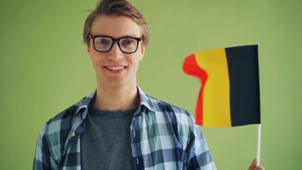 Slow Motion van mannelijke student Patriot Holding vlag van Duitsland en glimlachend — Stockvideo
