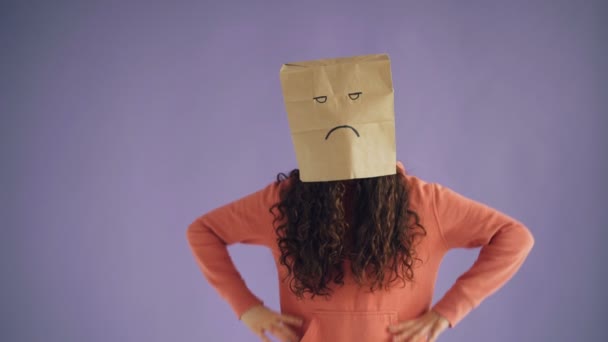 Retrato de chica con bolsa de papel en la cabeza mostrando mierda gesto sintiéndose enojado — Vídeos de Stock