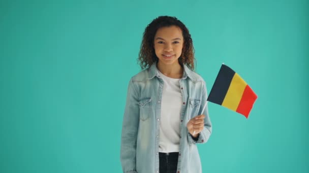Cámara lenta de linda chica afroamericana sosteniendo bandera alemana y sonriendo — Vídeos de Stock