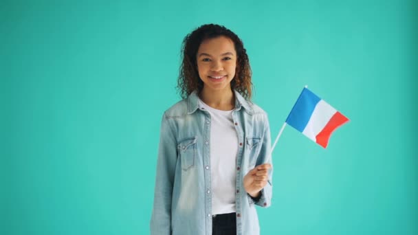 Cámara lenta de raza mixta dama francesa ondeando bandera oficial y sonriendo — Vídeos de Stock