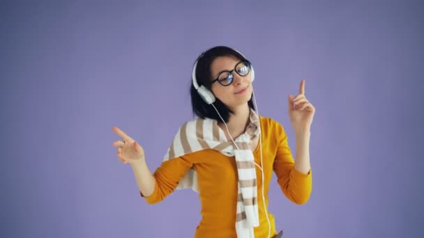 Portret van zorgeloze hipster luisteren naar muziek in een koptelefoon en dansen — Stockvideo