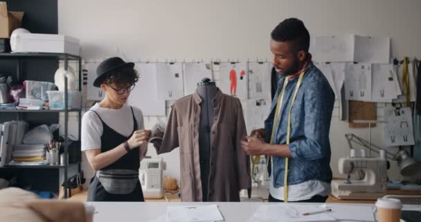 Aparadores que miden la prenda en el maniquí con cinta métrica hablando — Vídeos de Stock