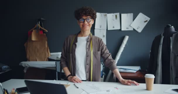 Retrato de la joven costurera sonriente mirando a la cámara de pie en el estudio — Vídeos de Stock