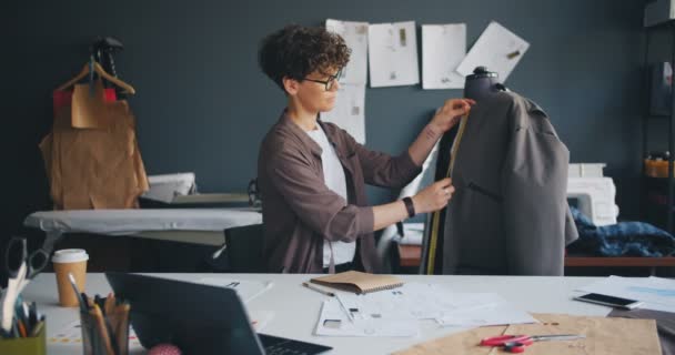 Vestuário de medição de costureira bonita em informações de escrita fictícia no notebook — Vídeo de Stock