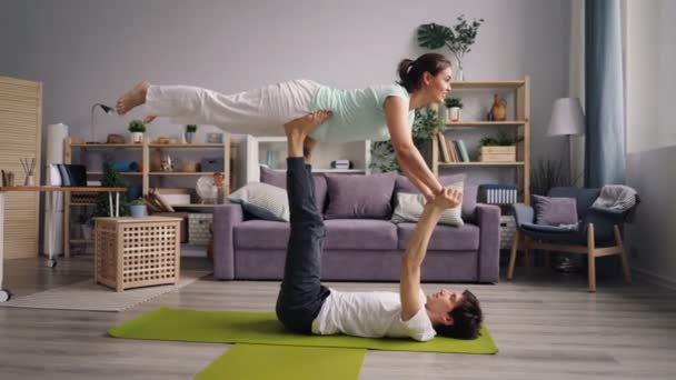 Güzel kız evde destek ile denge pratik erkek arkadaşı ile yoga yapıyor — Stok video