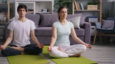 Karı koca evde birlikte meditasyon lotus pozisyonda istirahat