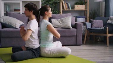 Öğrenciler kız ve adam kapalı gözlerle arka arkaya katta oturan meditasyon