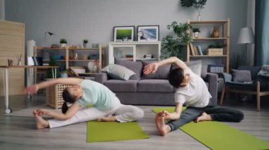 Genç aile karı koca sonra lotus pozisyonda rahatlatıcı yoga yapıyor