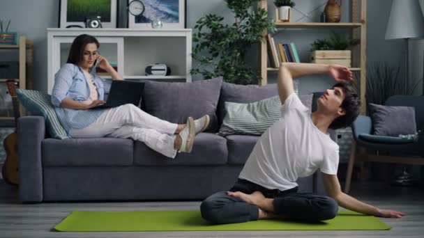 Kvinnlig frilansare arbetar hemma med hjälp av laptop ringer när man gör yoga — Stockvideo